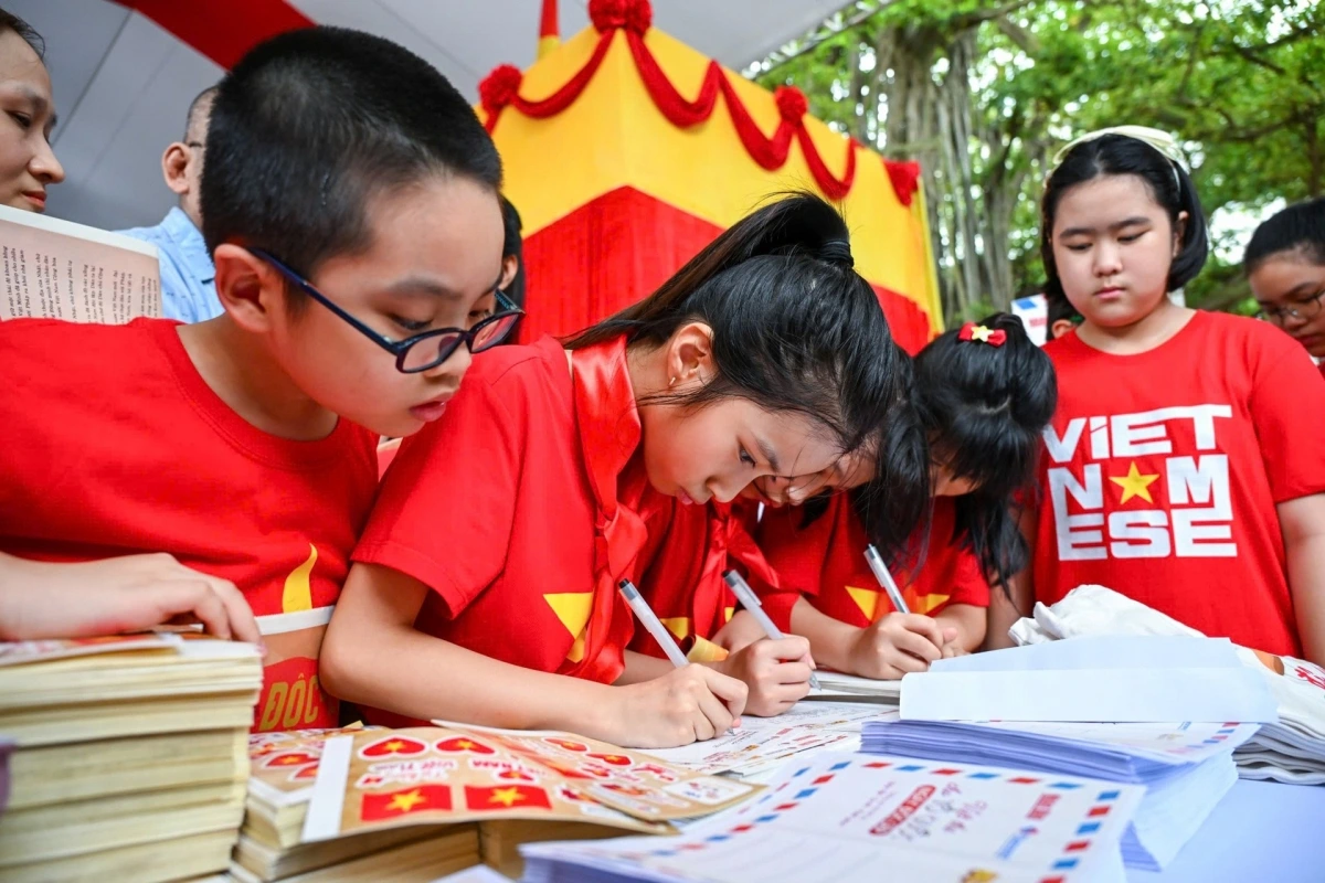 Các em nhỏ trải nghiệm tham gia viết thư cho Tổ quốc tại Triển lãm tương tác “80 năm rạng rỡ non sông - Con đường Độc lập”. Ảnh: Thành Đạt