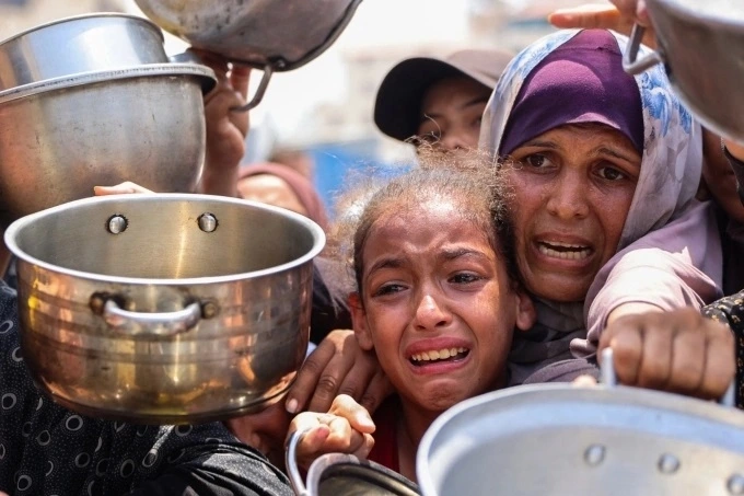 Người Palestine chờ nhận bữa ăn tại một trung tâm phân phối thực phẩm ở Gaza City ngày 13/8. (Ảnh: AFP)