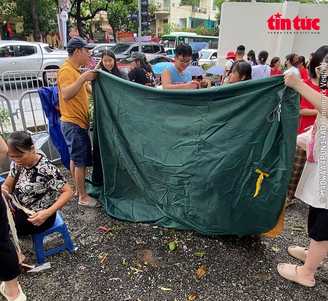 Lực lượng chức năng phường Ba Đình kiên quyết yêu cầu người dân tháo dỡ lều bạt không đúng quy định. (Ảnh: TTXVN)