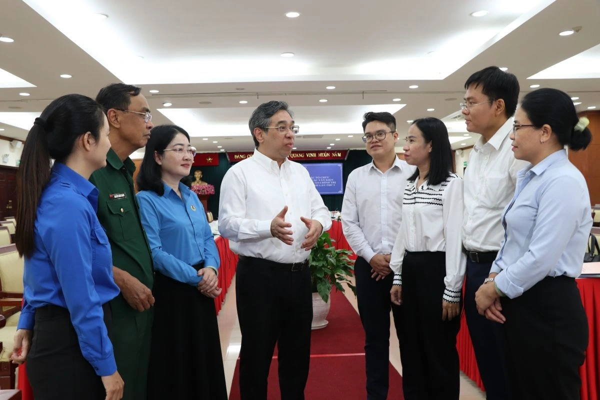 Phó Bí thư Thành ủy, Chủ tịch Ủy ban MTTQ TP.HCM Nguyễn Phước Lộc (thứ tư từ trái sang) trao đổi với các đại biểu dự hội nghị