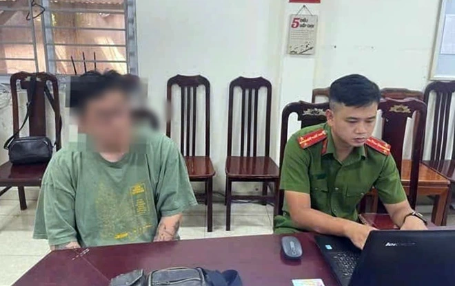 Đặng Chí T. (bên trái) tại cơ quan công an. (Ảnh: Công an cung cấp)