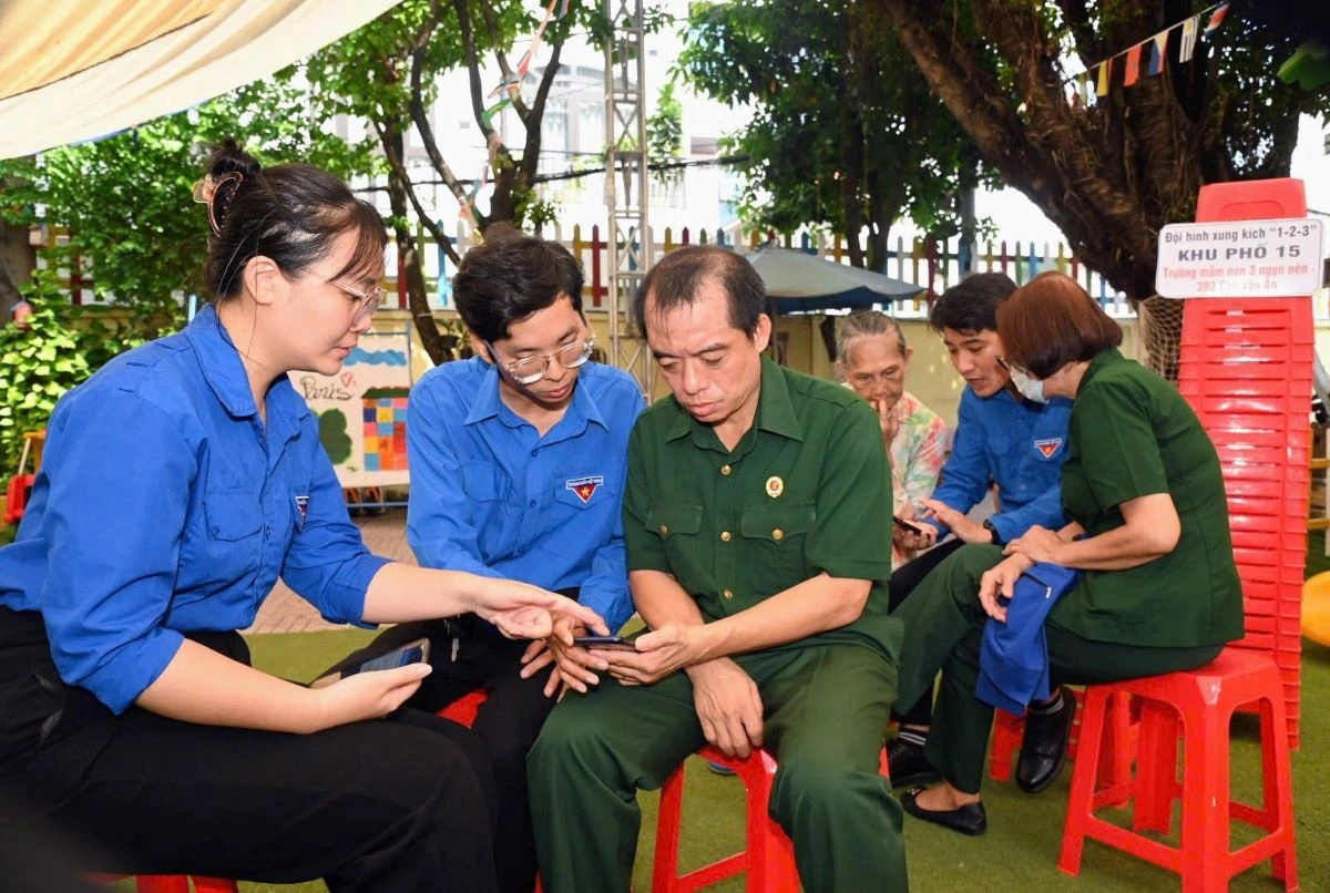 Đội hình xung kích 1-2-3 đang hướng dẫn người dân cài đặt, thao tác các ứng dụng trên điện thoại 