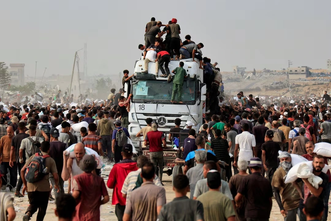 Người dân Gaza vây quanh xe tải chở hàng viện trợ tới đây. Ảnh: Reuters.