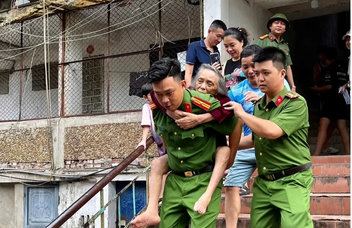 Lực Công an Nghệ An tham gia hỗ trợ người dân di dời tránh trú bão số 5. Ảnh: KT.