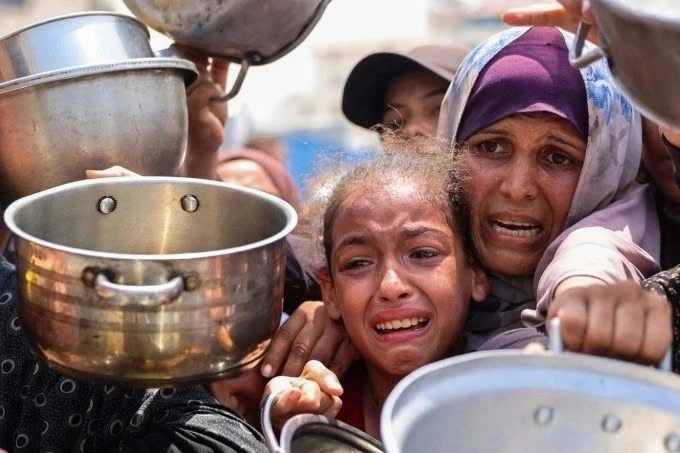 Người Palestine chờ nhận bữa ăn tại một trung tâm phân phối thực phẩm ở Gaza City ngày 13/8. (Ảnh: AFP)