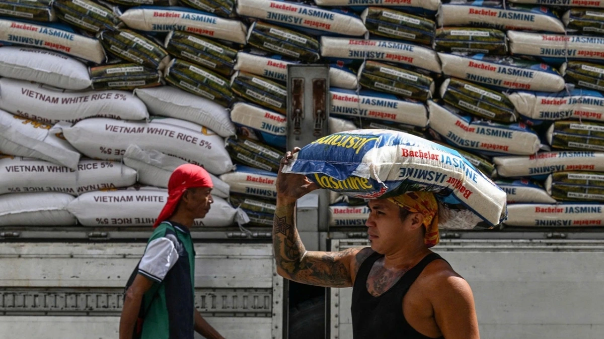 Một người đàn ông đội bao gạo ở Manila (Philippines) ngày 19.11.2024 Ảnh: AFP