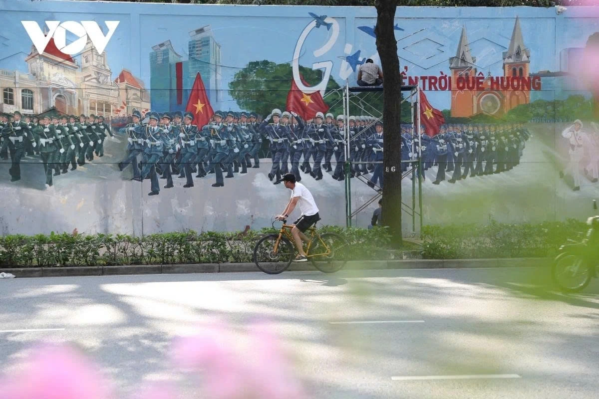 The painting evokes memories of wartime, depicting scenes with tanks, planes, and Biên Hoa Airport, among others. Peaceful life is also portrayed through vibrant images of national flags, joyful crowds, and fireworks at Bach Dang wharf.
