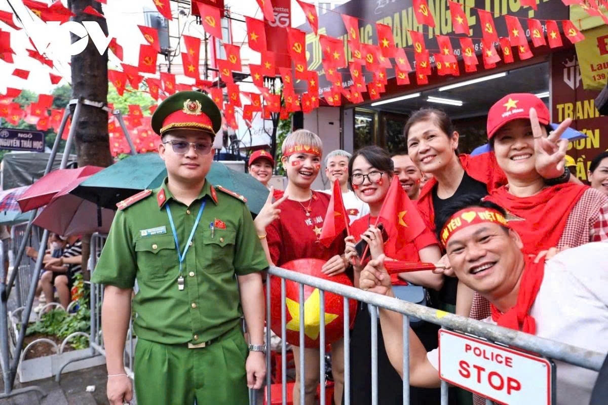 Despite facing spells of heavy rain, residents remain excited, waiting for the parade and march units to pass by.