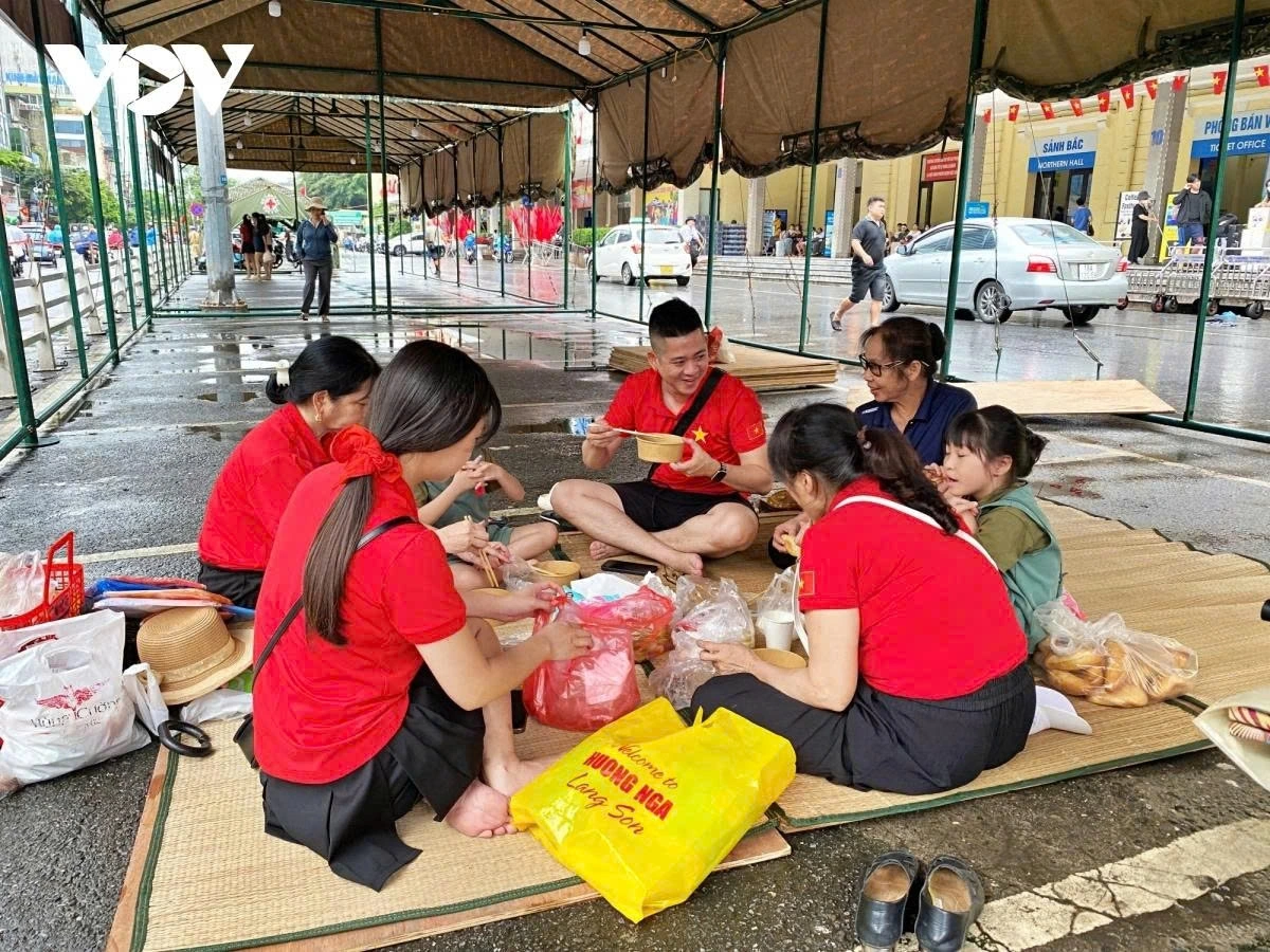 A family traveling from Tuyen Quang to Hanoi gather inside public tents set up by authorities to wait for the event