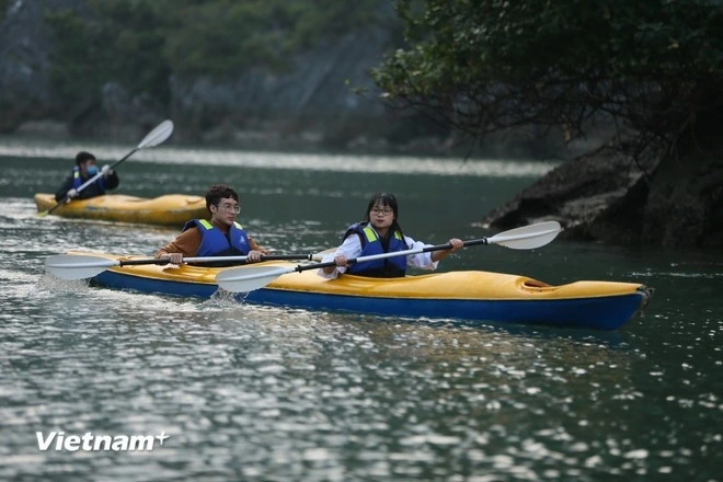 Tourists go kayaking in Ha Long Bay