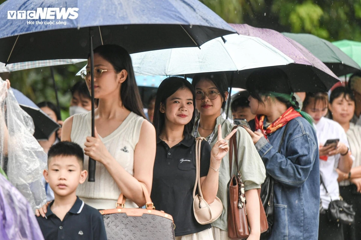 Trước cổng Trần Bình Trọng - điểm check-in chính thức của sự kiện, từng hàng người nối đuôi nhau kéo dài hàng trăm mét. Cơn mưa rào bất chợt không ngăn được dòng người đông đảo.