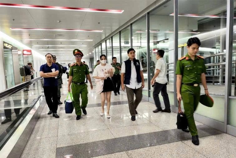 Ngô Thị Thêu (bế con nhỏ) bị dẫn giải về nước. Ảnh: Bộ Công an