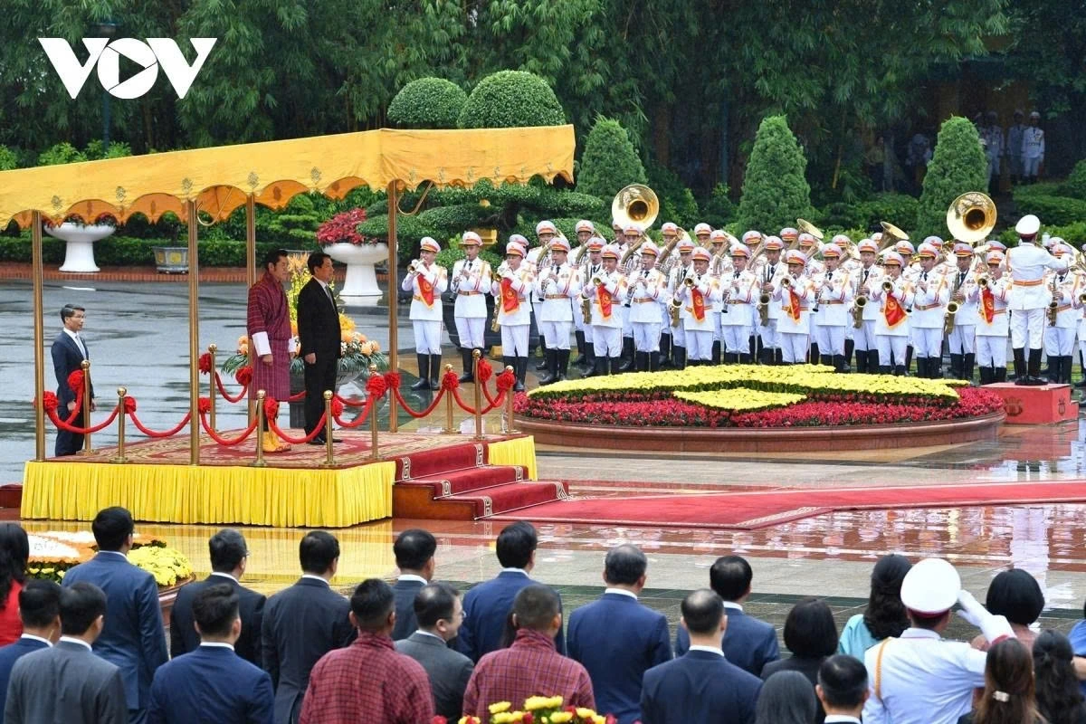 President Luong Cuong and the Bhutanese King stand on the honourary podium while military bands play the national anthems of both sides.