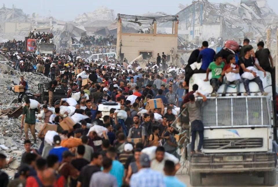 Người Palestine mang hàng viện trợ vào Dải Gaza qua ngả Israel, tại Beit Lahia, phía bắc Dải Gaza, ngày 29/7/2025. Ảnh: Reuters