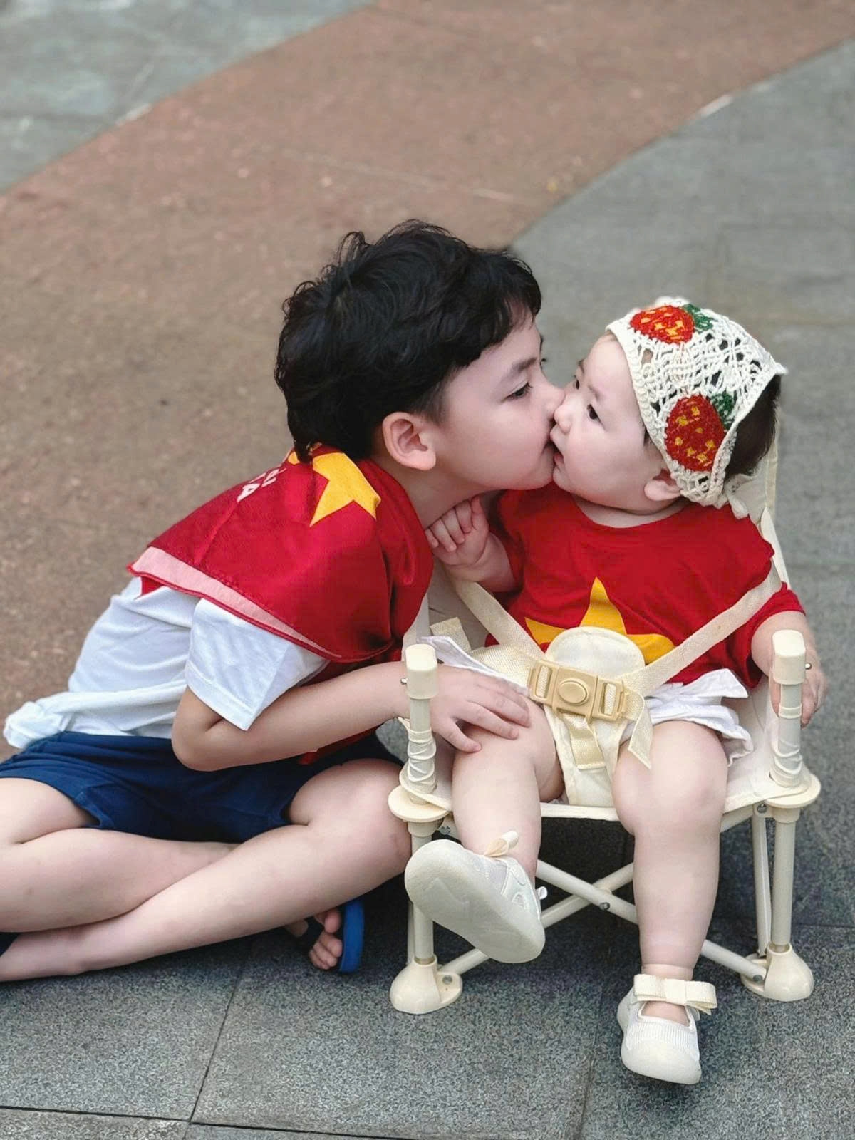Á hậu Dương Tú Anh đăng tải khoảnh khắc thân thiết của hai con kèm chú thích: "Con là Mochi, con chưa biết đứng, chưa mọc răng, nhưng con với anh trai đều là thành viên khối nhi đồng yêu Tổ quốc đấy ạ".