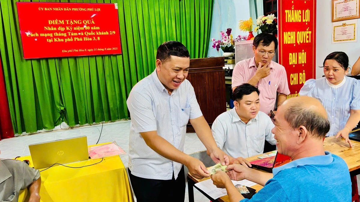 Lãnh đạo phường Phú Lợi làm thủ tục trao quà cho người dân 
