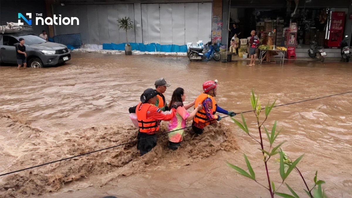 Lực lượng cứu hộ giúp người dân lội qua dòng nước lũ mạnh ở huyện Mae Chaem, Chiang Mai vào sáng 23/9/2025. Ảnh: The Nation