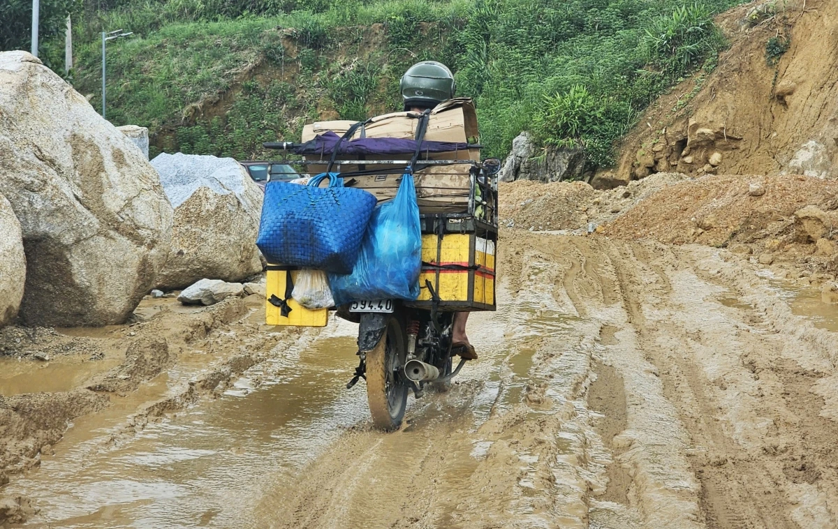 Người dân nhọc nhằn đi qua đoạn đường lầy lội.