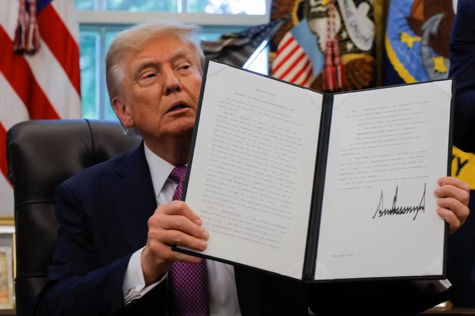 Tổng thống Mỹ Donald Trump cầm sắc lệnh hành pháp đã ký, đổi tên Bộ Quốc phòng thành Bộ Chiến tranh, tại Phòng Bầu dục, Nhà Trắng, ngày 5/9/2025. Ảnh: Reuters