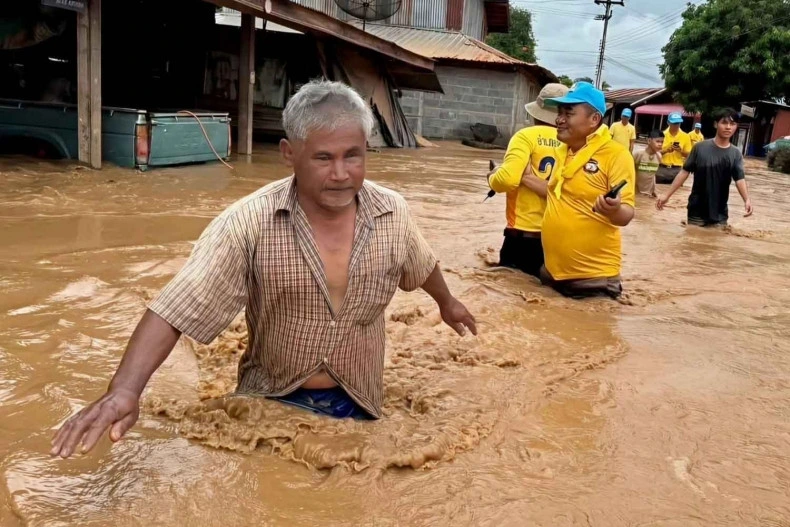 Người dân lội qua dòng nước lũ ngập đến thắt lưng tại huyện Lom Kao, tỉnh Phetchabun, Thái Lan vào hôm Chủ nhật (31/8/2025). (Ảnh: Soonthorn Kongwarakom/Bangkok Post)