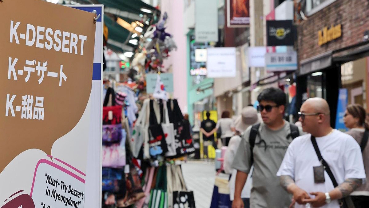 Du khách quốc tế dạo quanh các quầy hàng thực phẩm ở khu mua sắm và du lịch trung tâm Myeongdong, Seoul. (Ảnh: Yonhap)
