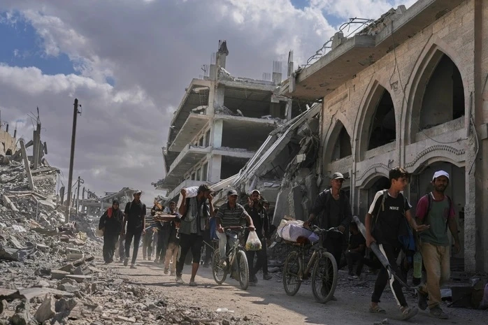 Người dân Palestine trở về TP Khan Younis, miền Nam Dải Gaza, hôm 10/10 sau khi lệnh ngừng bắn giữa Israel và nhóm vũ trang Hamas được thực thi. (Ảnh: AP)