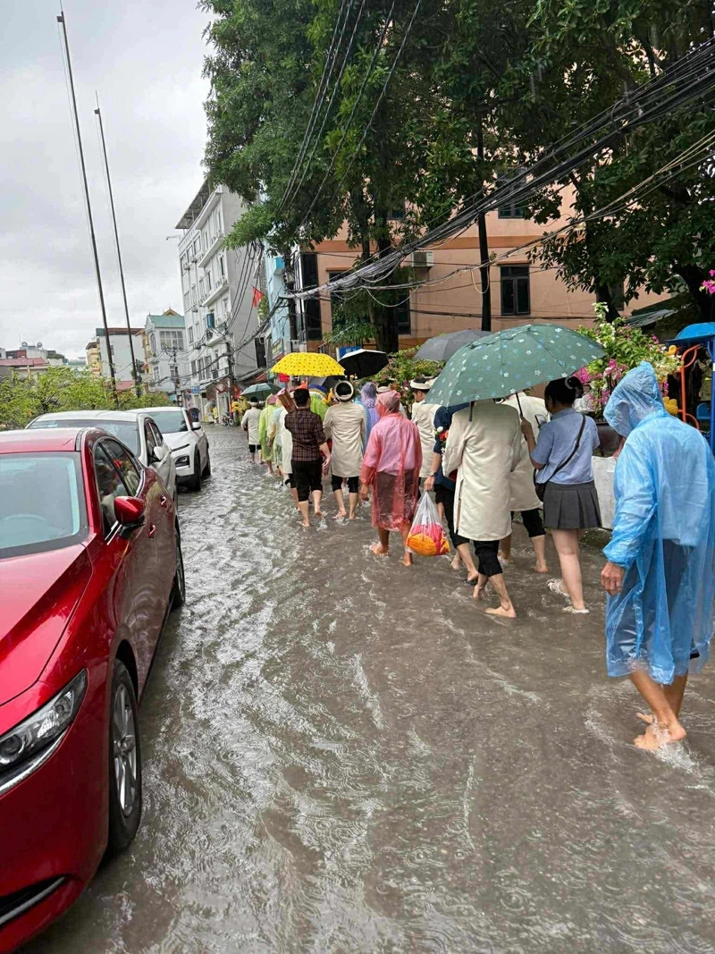 Nhà trai mặc áo mưa, che ô, lội nước đi đón dâu (Ảnh: NVCC)