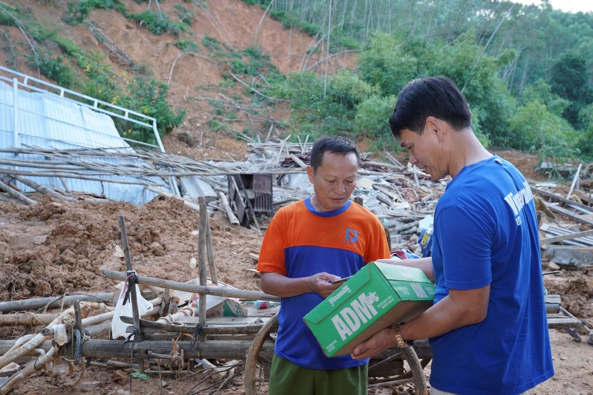 Ông Nông Văn Chiến, xã Thiện Tân, tỉnh Lạng Sơn trước căn nhà đổ nát nhận sự sẻ chia từ ông Phạm Tuyên – Giám đốc chi nhánh Hà Nội, Vinamilk (Ảnh: Tịnh Không)