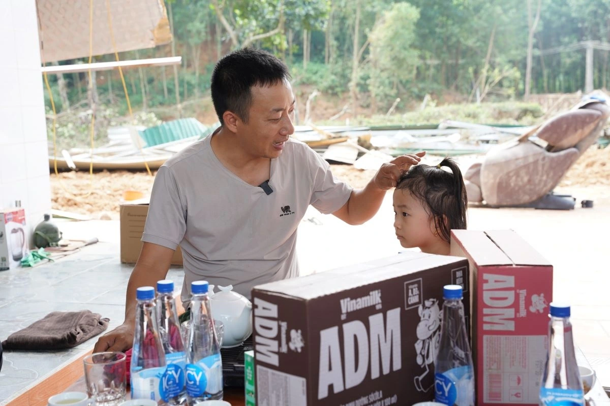 Anh Đoàn Khanh và con gái nhỏ trước ngôi nhà đã bị lũ cuốn trôi toàn bộ (Ảnh: Tịnh Không)