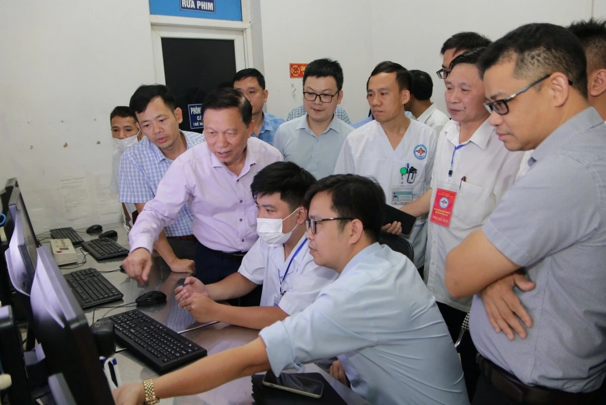 PGS. TS. Trần Quý Tường (đứng thứ ba hàng đầu) kiểm tra việc triển khai hồ sơ bệnh án điện tử tại cơ sở (Ảnh - VGP)
