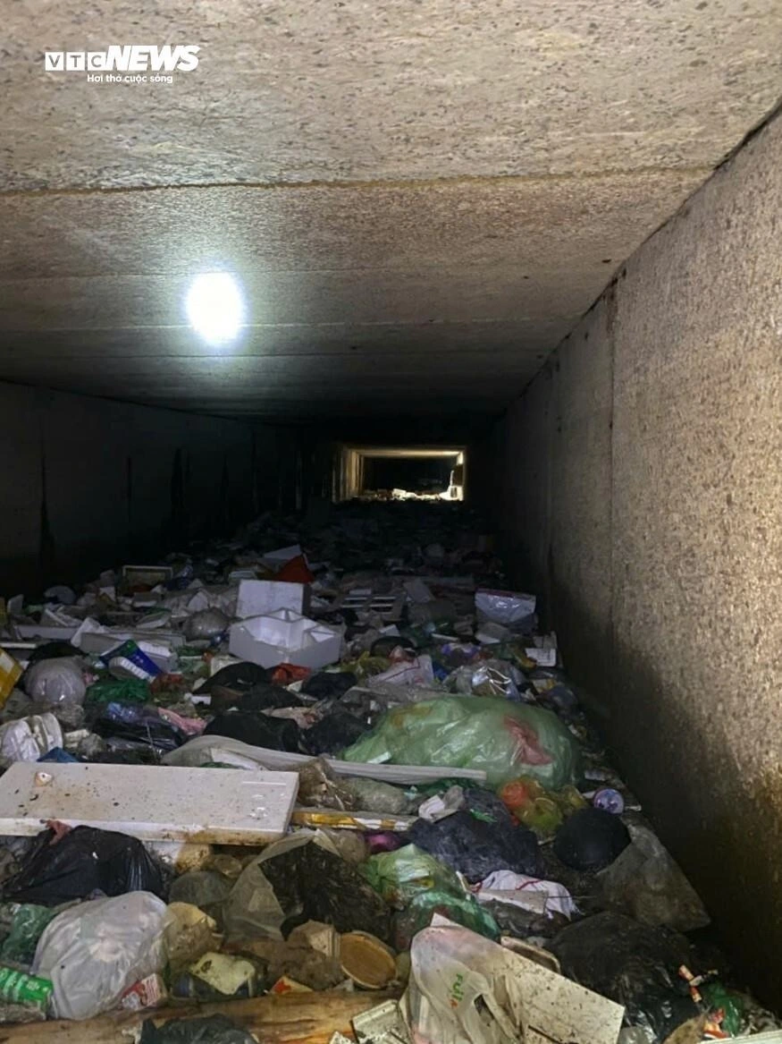 Một đoạn cống ngầm dài ngổn ngang đủ loại rác thải sinh hoạt, che kín cả lối đi.