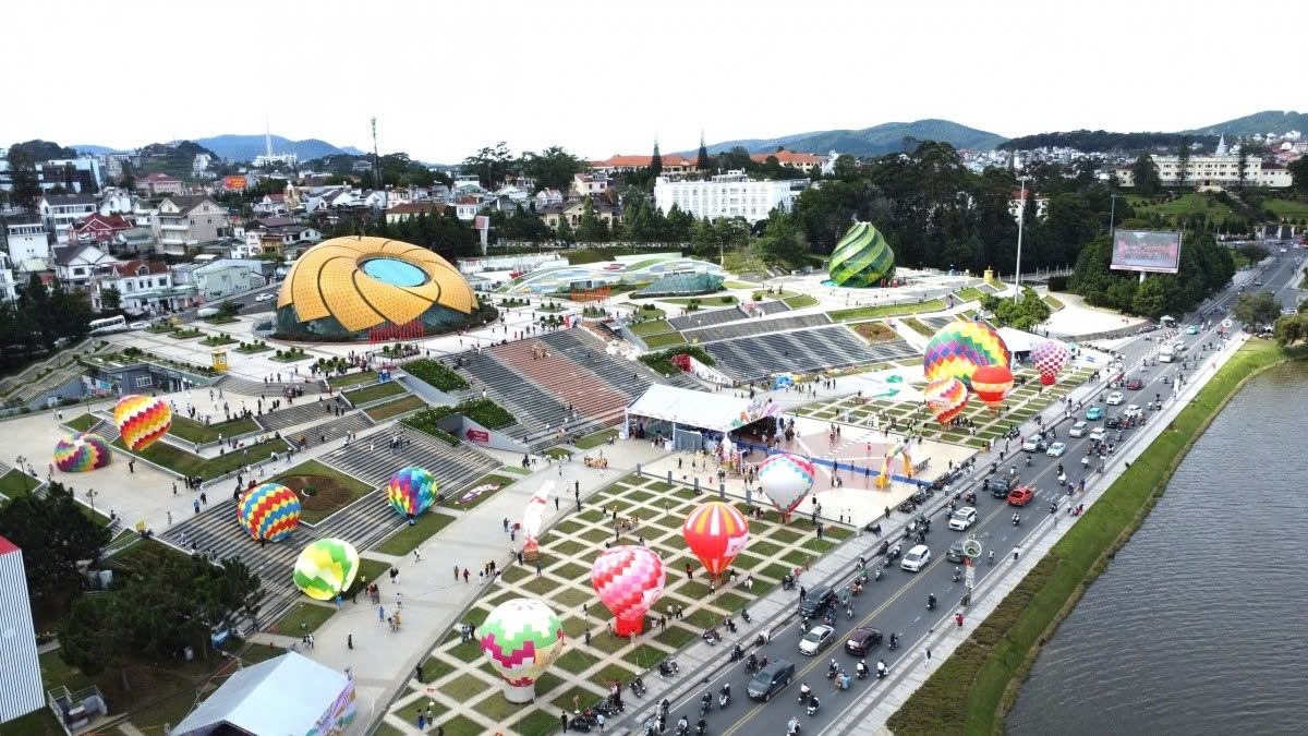 A panoramic view of Lam Vien Square is seen from high above. Dozens of hot air balloons fly simultaneously, creating a vivid picture on the background of Xuan Huong Lake.