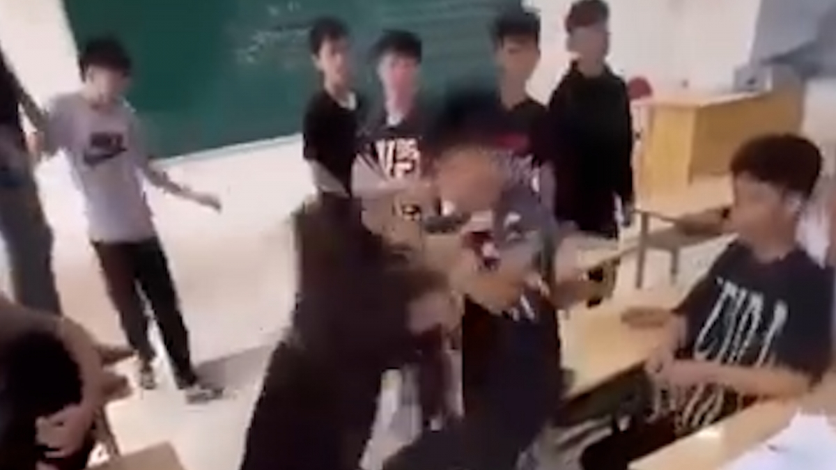 Nhiều nam sinh hò hét cổ vũ nam sinh và nữ sinh đánh nhau. Ảnh: Cắt từ video.
