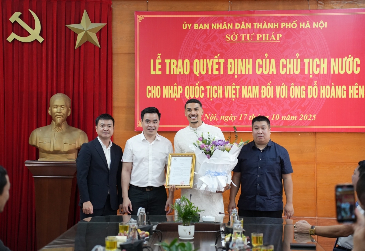 Đỗ Hoàng Hên trong trang phục áo dài truyền thống nhận quyết định nhập tịch Việt Nam.