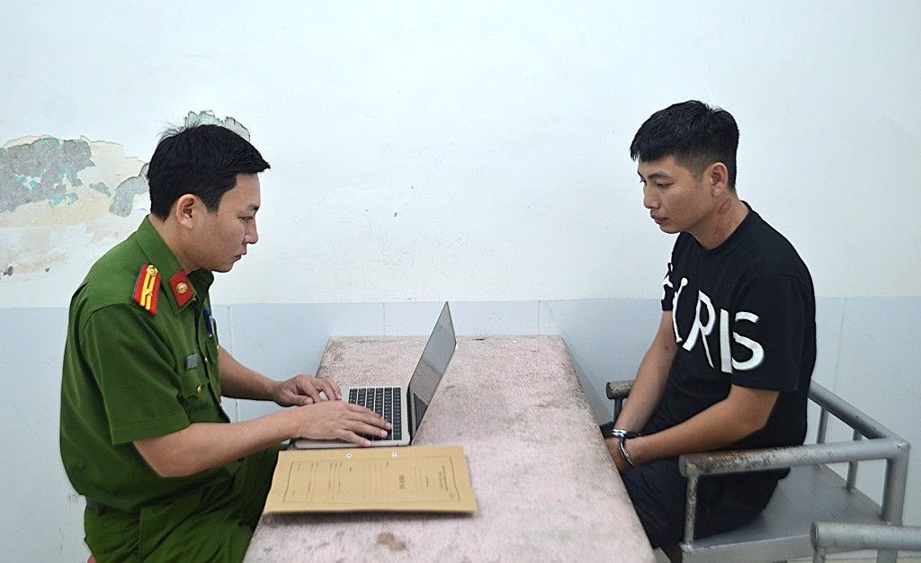 Cán bộ Phòng Cảnh sát hình sự Công an Nghệ An lấy lời khai đối tượng Bàn Văn Vỹ. Ảnh: Phạm Thủy.
