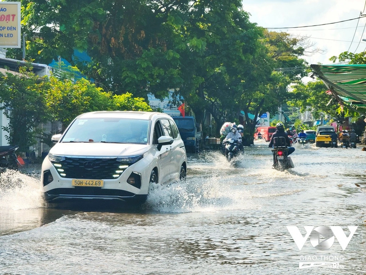Dòng người vất vả vượt qua đoạn đường ngập sâu, đối mặt với nguy cơ té ngã và xe chết máy.