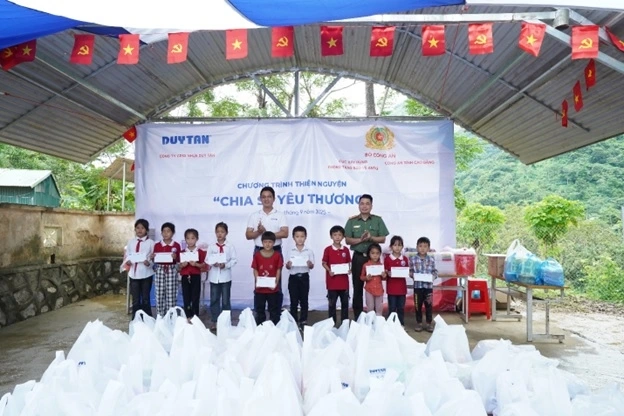 Ông Nguyễn Ngọc Thành – Giám đốc Marketing Nhựa Duy Tân và Trung tá Nguyễn Thế Nam, Trưởng phòng Công tác dân vận, Cục Xây dựng phong trào bảo vệ ANTQ tặng quà cho các học sinh tại điểm Trường Tiểu học Nà Đon (xã Quảng Lâm)