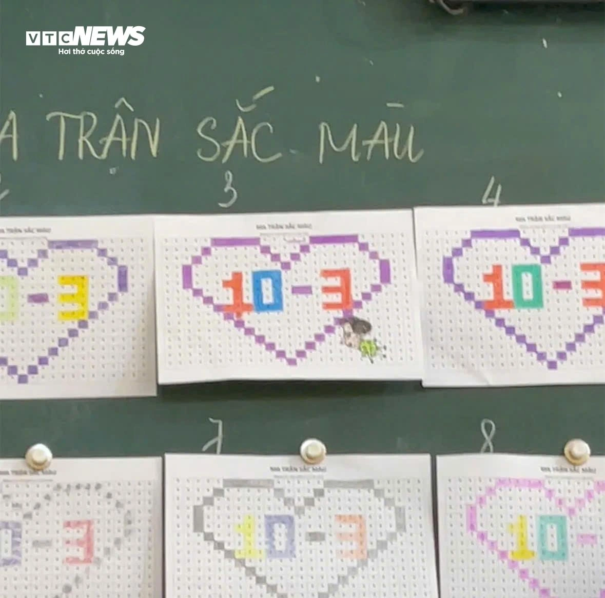 Với đề bài này, học sinh tô màu theo dạng ma trận, tạo nên hình trái tim cùng dòng chữ “10-3” từ nhiều ô vuông nhỏ. Mỗi bài làm thể hiện sự sáng tạo qua cách phối màu đa dạng và sinh động.