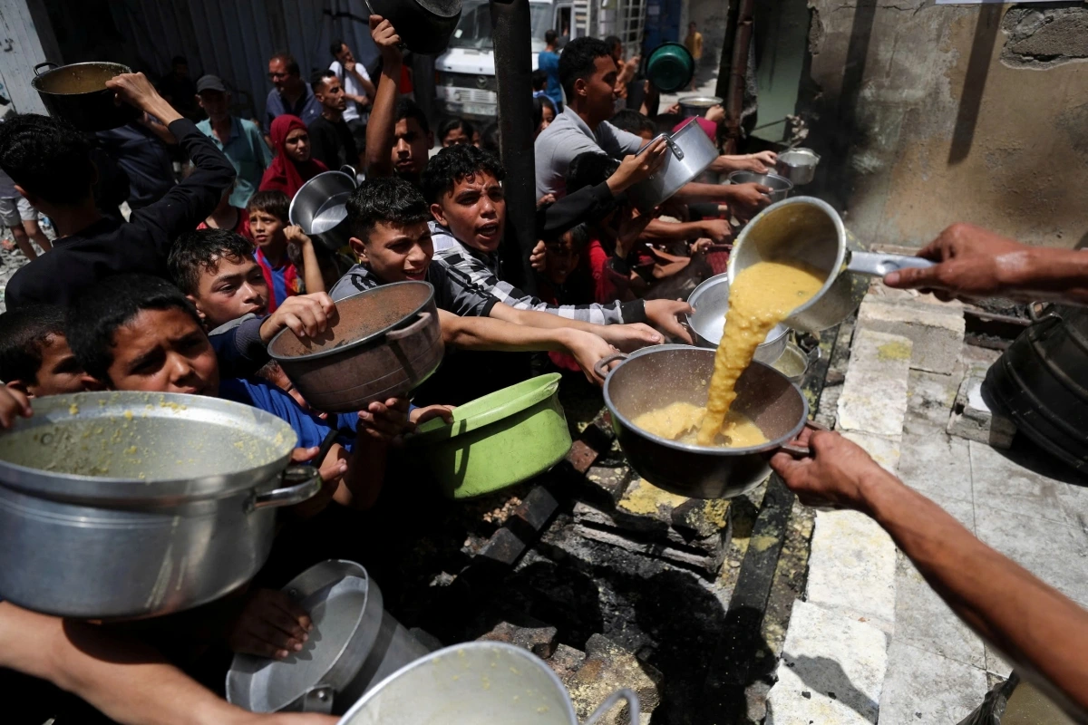Người Palestine chờ nhận thực phẩm từ một bếp ăn từ thiện tại Gaza (Ảnh: Reuters)