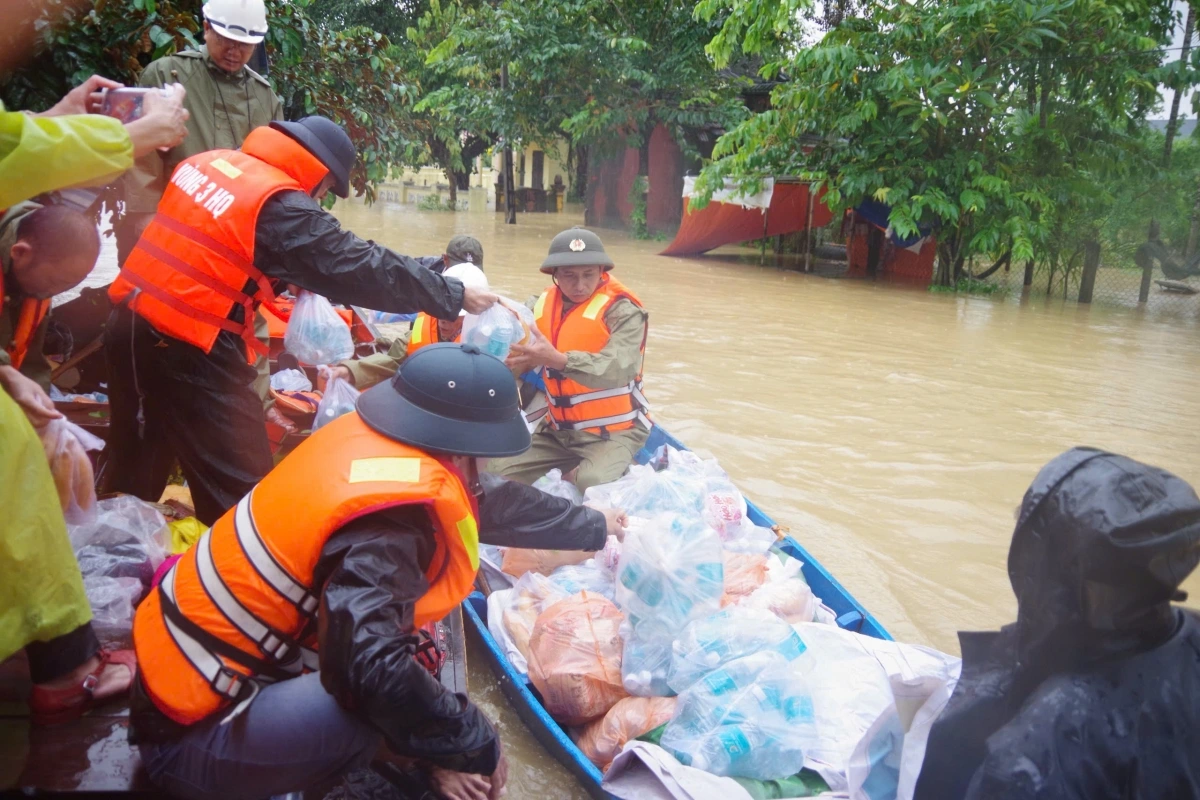 Cán bộ, chiến sĩ Vùng 3 Hải quân chuyển lương thực, nước uống xuống xuồng nhỏ để chuyển đến tay người dân. (Ảnh: Quân chủng Hải quân)