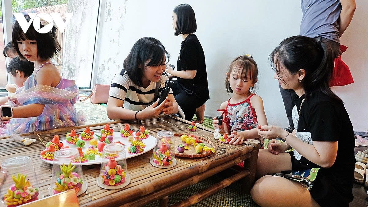 Children are guided to create five fruit trays from sticky rice flour.