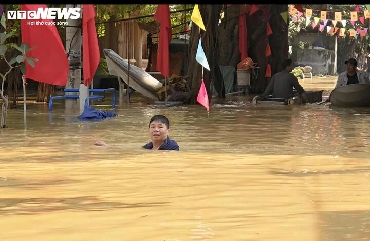 Con đường mọi khi nay biến thành "dòng sông" ngập gần tới cổ ông Lợi.