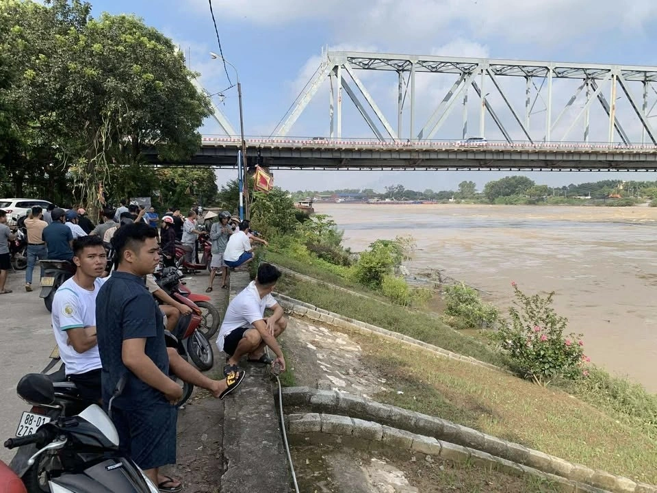 Người dân theo dõi sự việc trên bờ.