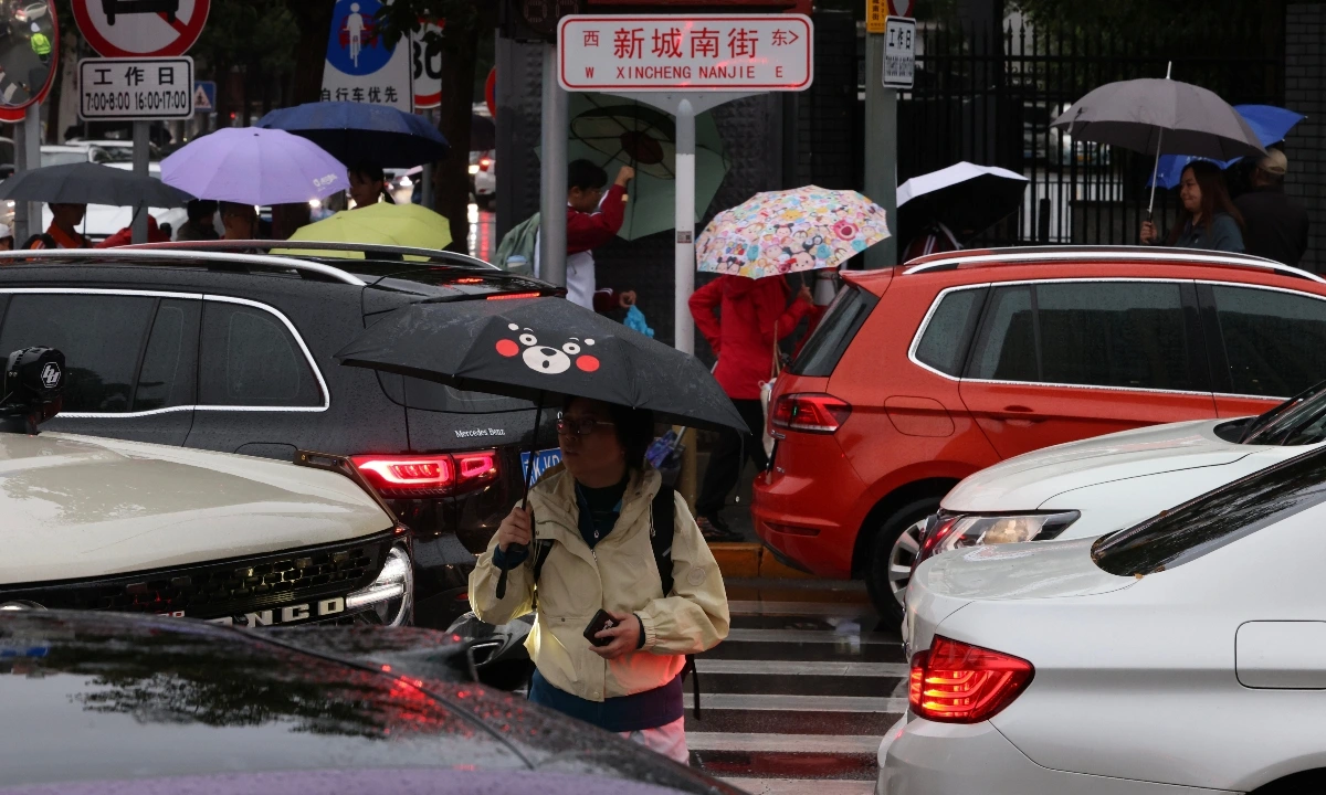Người dân quận Thông Châu, Bắc Kinh đi làm, đi học dưới trời mưa liên tục vào giờ cao điểm buổi sáng ngày 9/10/2025. Ảnh: IC