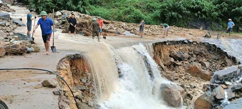 Lực lượng chức năng xã Tiên Yên và người dân tham gia khắc phục thông tuyến đường bị sạt lở. Ảnh: Trần Hoàn/TTXVN phát