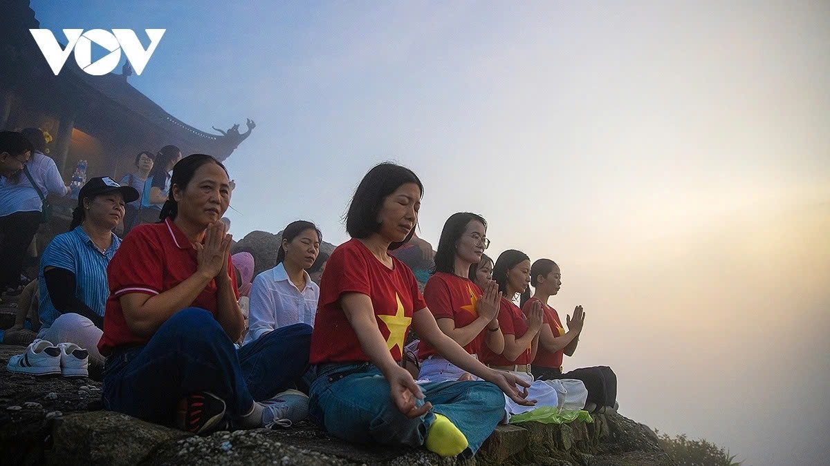 The early morning air on the mountain peak is a bit chilly and fresh, making everyone feel calm and relax. Nguyen Thi Ngoc Anh from Hong Gai ward, Quang Ninh, shares that she feels as if she blends into nature. After practicing yoga, she and other tourists enjoy drinking tea and watching the sunrise.