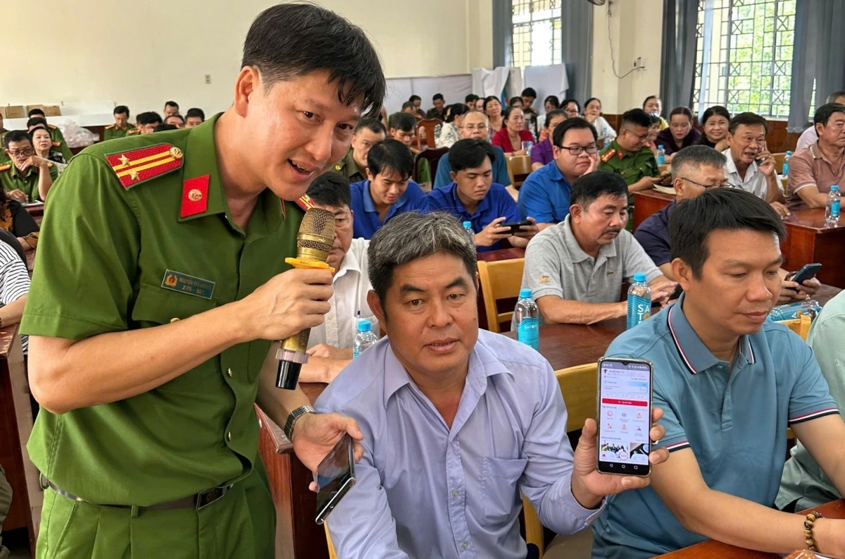 Trung tá Nguyễn Thế Hoàng tận tình hướng dẫn người dân làm thủ tục.