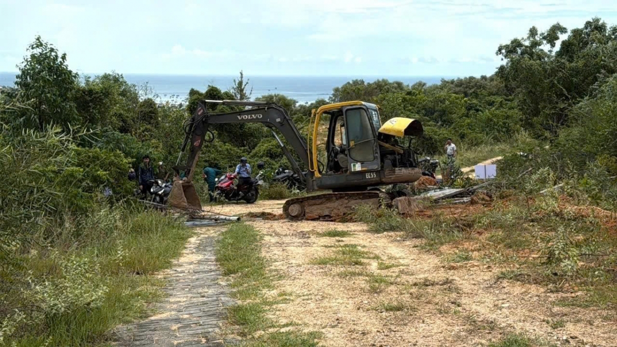 Xe múc phá dỡ hàng rào khu vực đất lấn chiếm. Ảnh: B.H