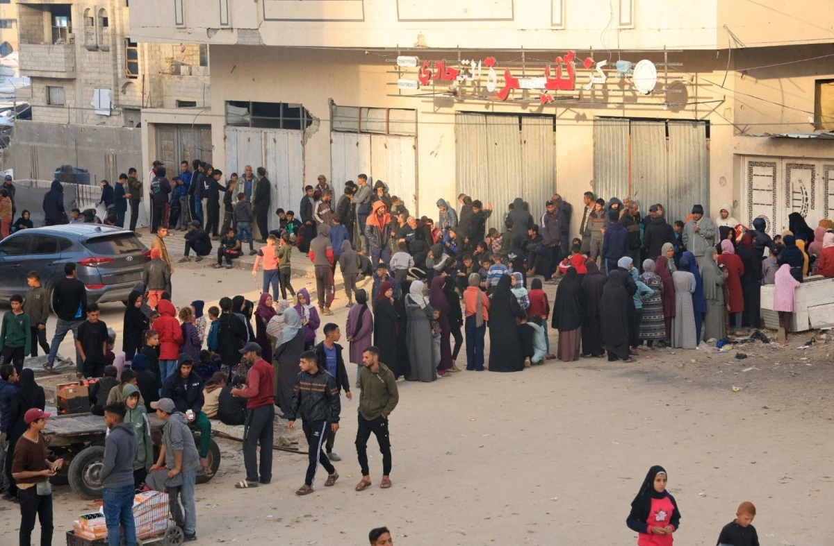 Người dân Palestine chờ mua bánh mì tại một điểm phân phát ở Khan Younis. Ảnh: Reuters