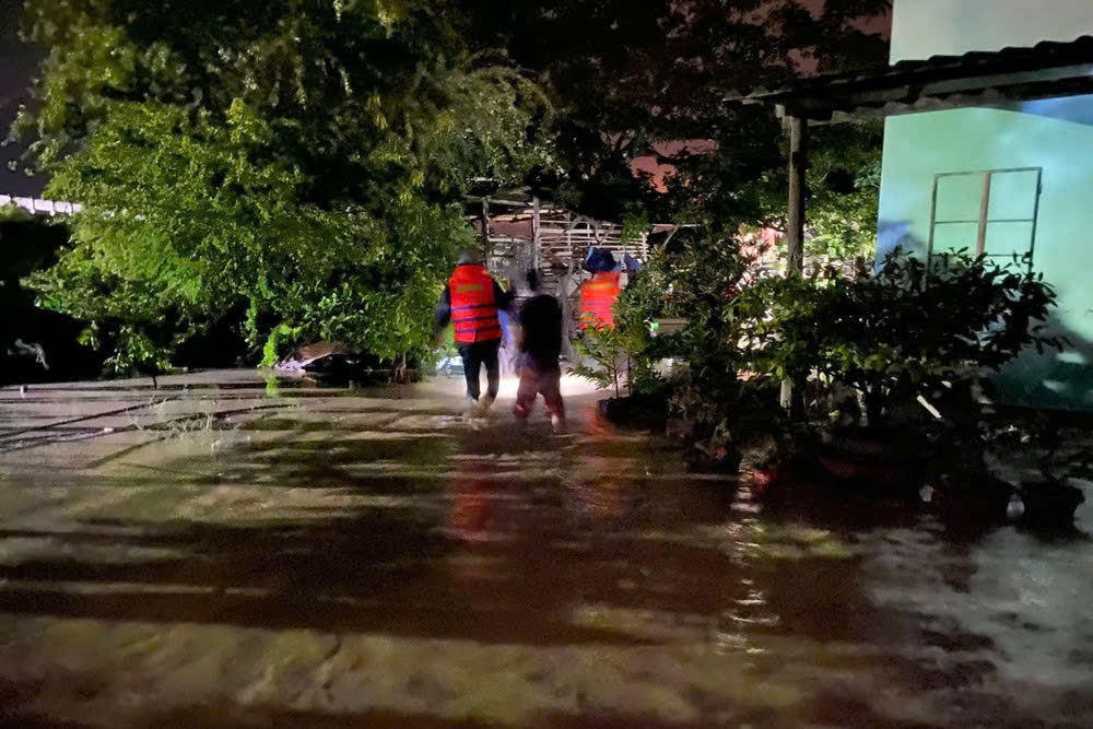 Lực lượng chức năng xã Tuy Phong khẩn trương di dời người dân trong đêm sau khi hồ chứa nước tại trang trại nuôi gia cầm trên núi bị vỡ, gây ngập sâu nhiều nhà dân ở khu vực hạ lưu. Ảnh người dân cung cấp.